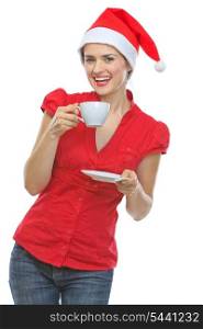Happy young woman in Santa hat drinking hot beverage
