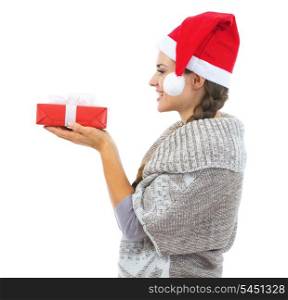 Happy young woman in sweater and christmas hat looking on christmas present box