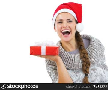 Happy young woman in sweater and christmas hat showing christmas present box