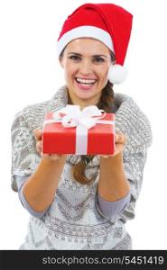 Happy young woman in sweater and christmas hat showing christmas present box