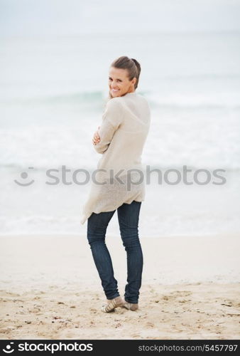 Happy young woman in sweater on beach