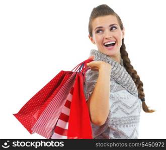 Happy young woman in sweater with christmas shopping bags looking on copy space