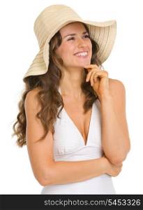 Happy young woman in swimsuit and hat looking on copy space