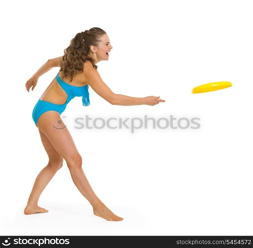 Happy young woman in swimsuit playing with frisbee