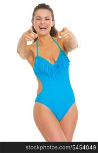 Happy young woman in swimsuit pointing in camera