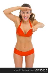Happy young woman in swimsuit pointing in camera