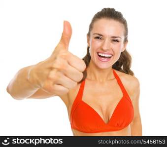 Happy young woman in swimsuit showing thumbs up