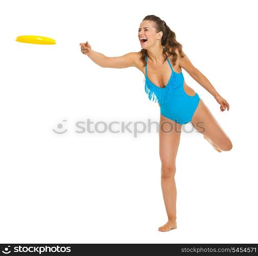 Happy young woman in swimsuit throwing flying disc