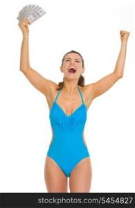 Happy young woman in swimsuit with fan of dollars rejoicing success