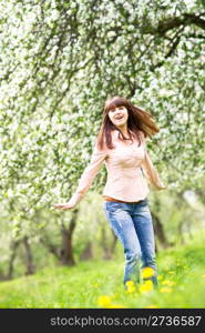 Happy young woman in the blooming garden