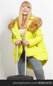 Happy young woman in warm jacket with suitcase. Gorgeous blonde tourist travel girl. Tourism.