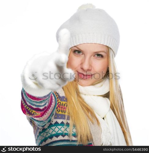 Happy young woman in winter clothes pointing in camera