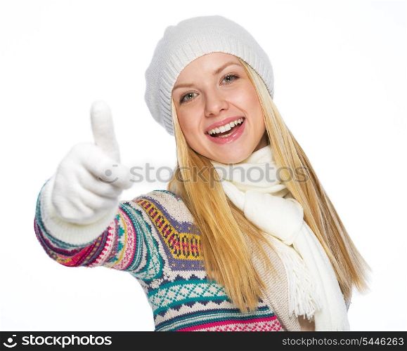 Happy young woman in winter clothes showing thumbs up