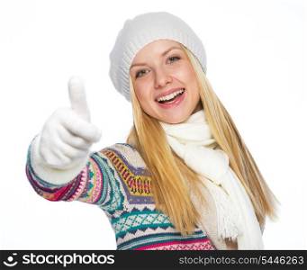 Happy young woman in winter clothes showing thumbs up