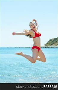 Happy young woman jumping at seaside