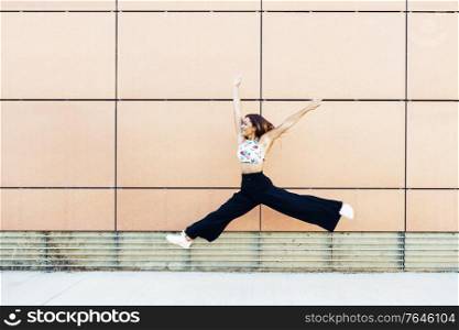 Happy young woman jumping in urban background. Geneneration Z girl. Happy young woman jumping in urban background