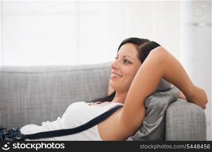 Happy young woman laying on couch