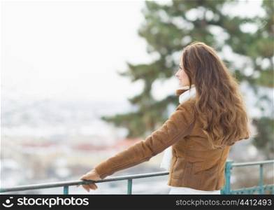 Happy young woman looking into distance in winter outdoors