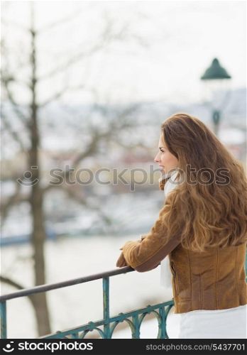 Happy young woman looking into distance in winter outdoors