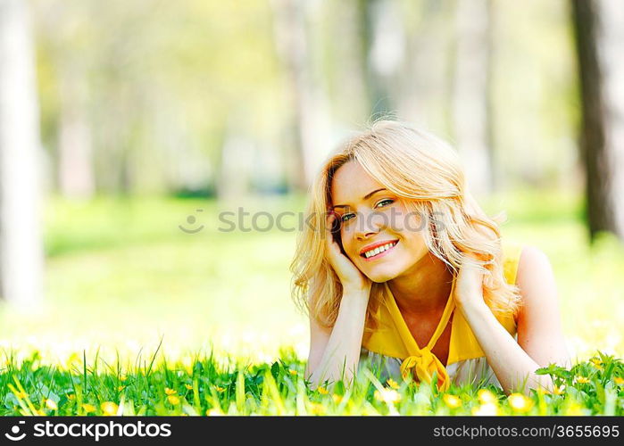 Happy young woman lying on grass