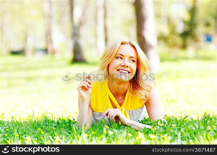 Happy young woman lying on grass