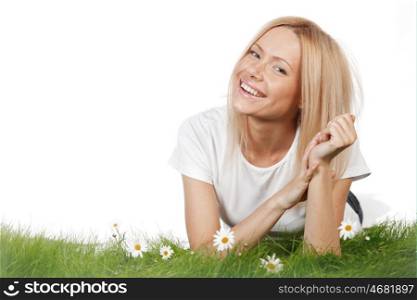 Happy young woman lying on grass with chamomile flowers, isolated on white background