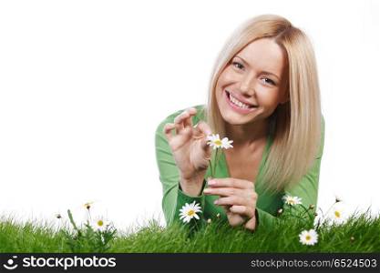 Happy young woman lying on grass with chamomile flowers, isolated on white background. Woman on grass with flowers