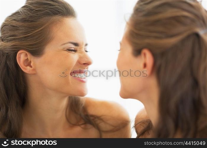Happy young woman making funny face in mirror