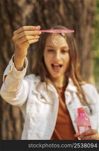 happy young woman making soap bubbles