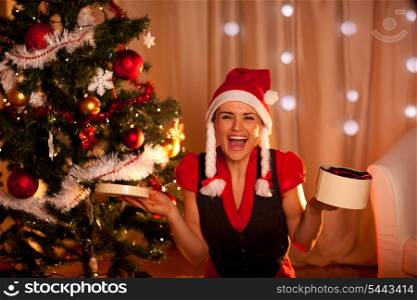 Happy young woman near Christmas with open gift&#xA;