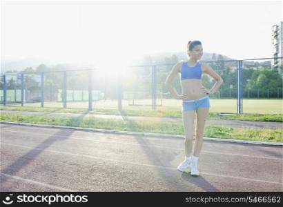 happy young woman on athletic race track relax