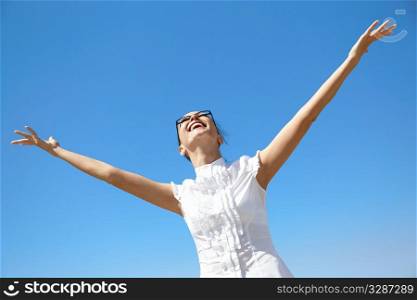 happy young woman on blue sky background, natural sunlight, selective focus