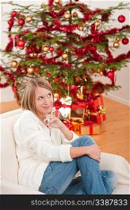 Happy young woman on Christmas in front of tree