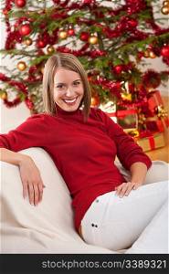 Happy young woman on Christmas in front of tree