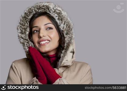 Happy young woman on winter clothes looking away