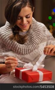 Happy young woman opening Christmas present box