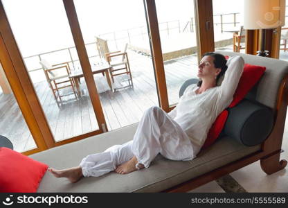 happy young woman relax at home on sofa in bright living room and watching tv