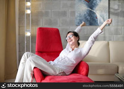 happy young woman relax at home on sofa in bright living room and watching tv