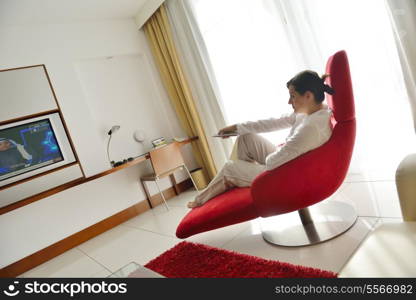 happy young woman relax at home on sofa in bright living room and watching tv