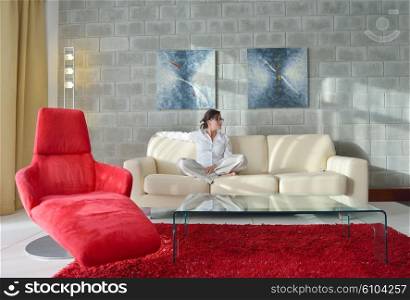 happy young woman relax at home on sofa in bright living room and watching tv