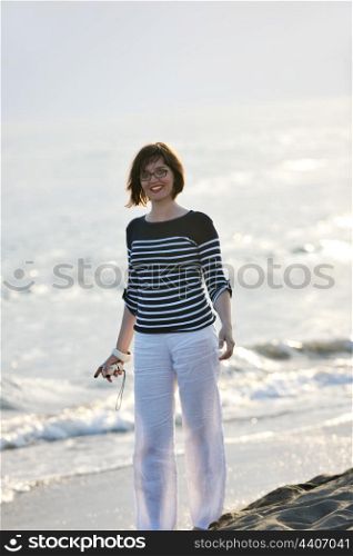 happy young woman relax on beautiful beach at fresh summer morning and enjoy first ray of sun