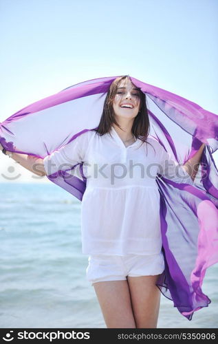 happy young woman relax on beautiful beach at fresh summer morning and enjoy first ray of sun