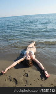 happy young woman relax on beautiful beach at fresh summer morning and enjoy first ray of sun