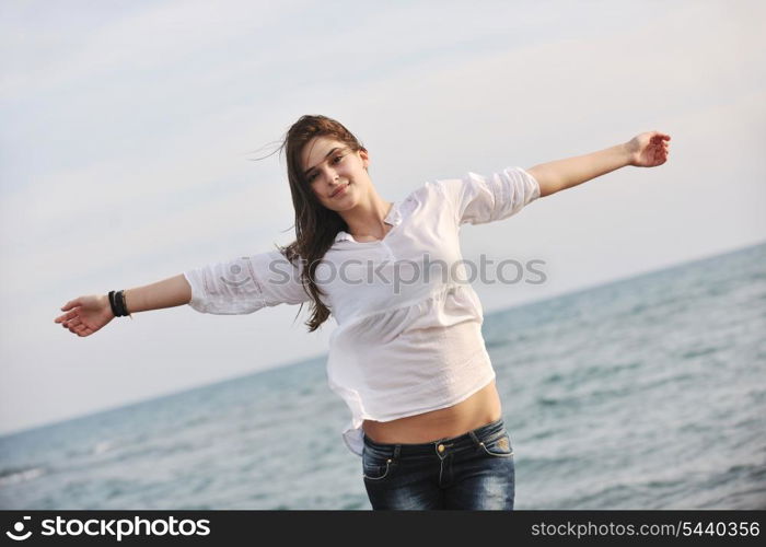 happy young woman relax on beautiful beach at fresh summer morning and enjoy first ray of sun