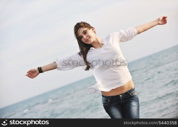 happy young woman relax on beautiful beach at fresh summer morning and enjoy first ray of sun