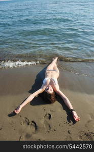 happy young woman relax on beautiful beach at fresh summer morning and enjoy first ray of sun