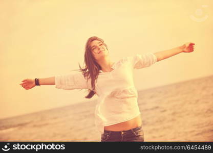 happy young woman relax on beautiful beach at fresh summer morning and enjoy first ray of sun