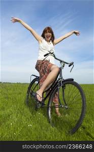 Happy young woman relaxing over a vintage bicycle