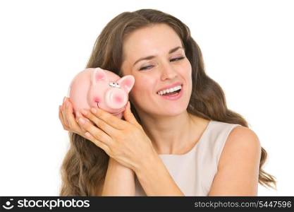 Happy young woman shaking piggy bank