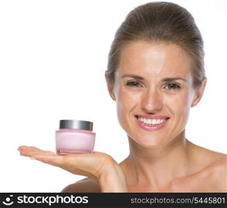 Happy young woman showing cream bottle